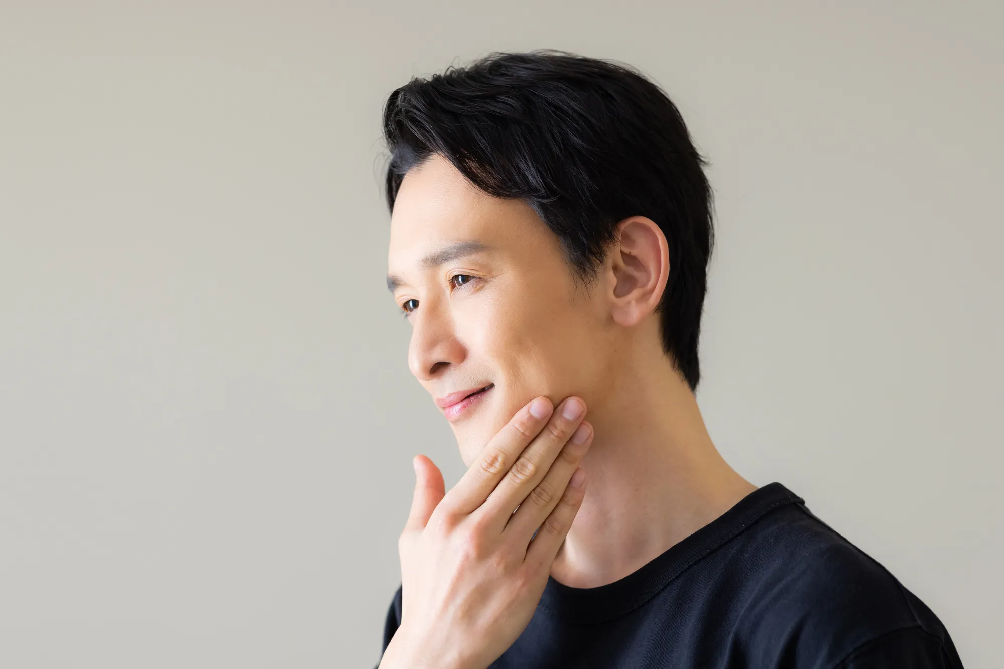 ヒゲを触っている男性の写真